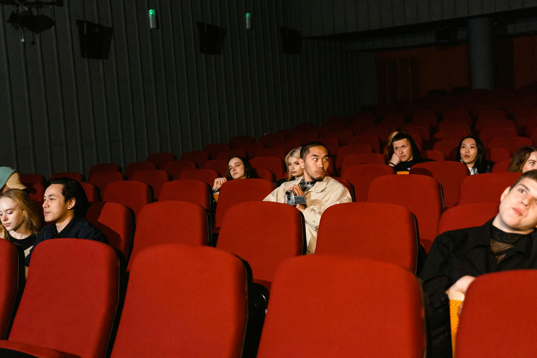 Widzowie oglądający film w prawie pustej sali kinowej