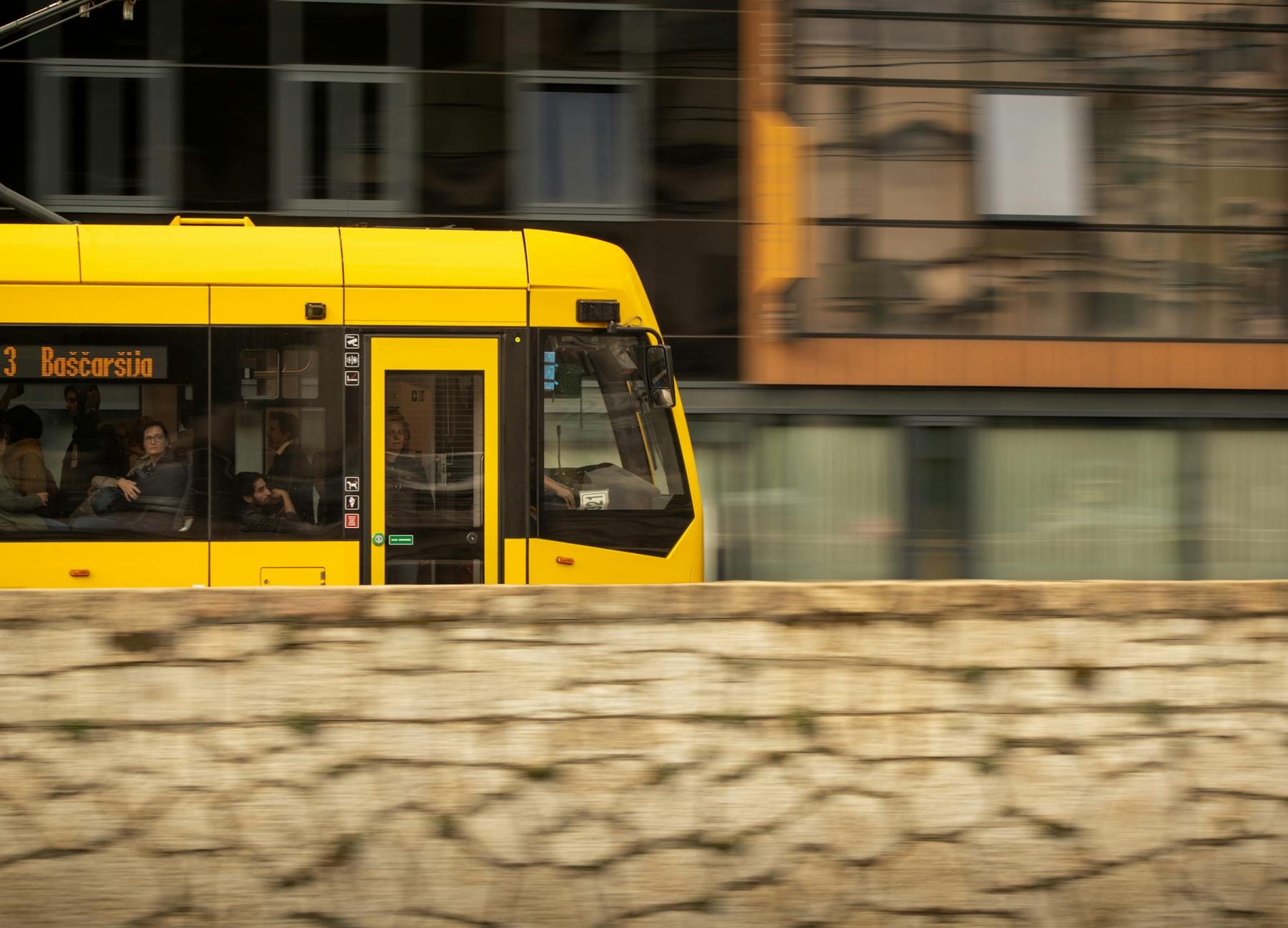 Żółty tramwaj jadący ulicą w zabytkowej części miasta